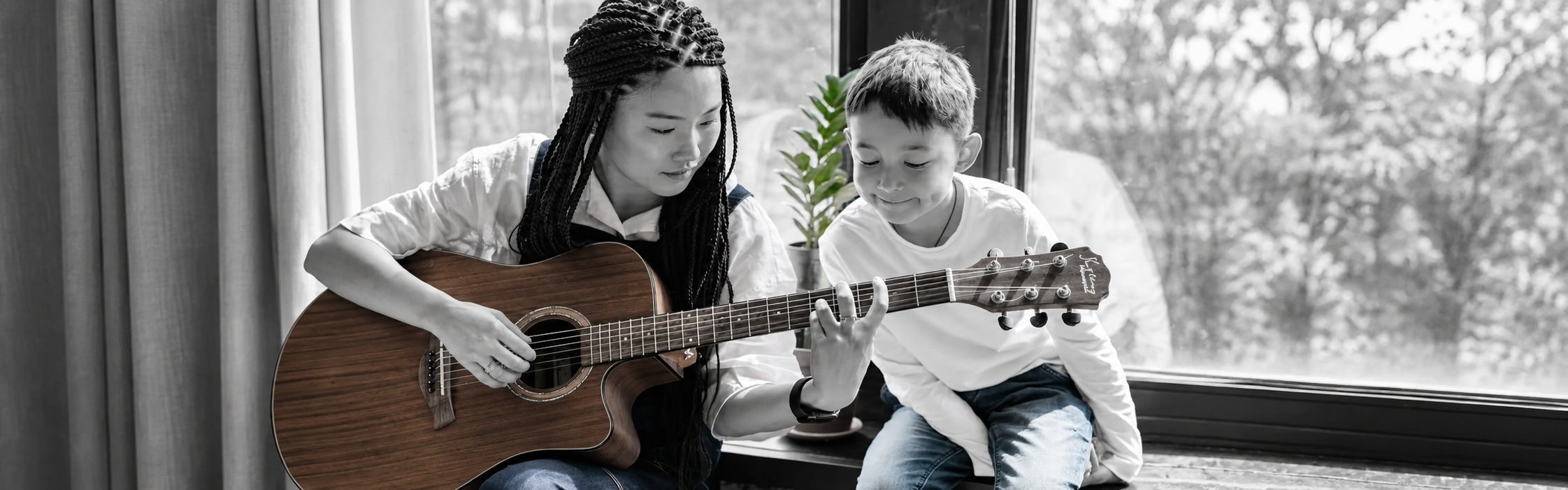 Music therapist teaching a child guitar during a music therapy session at Global Rehabilitation Service